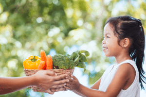 Jeune fille tient un panier de légumes